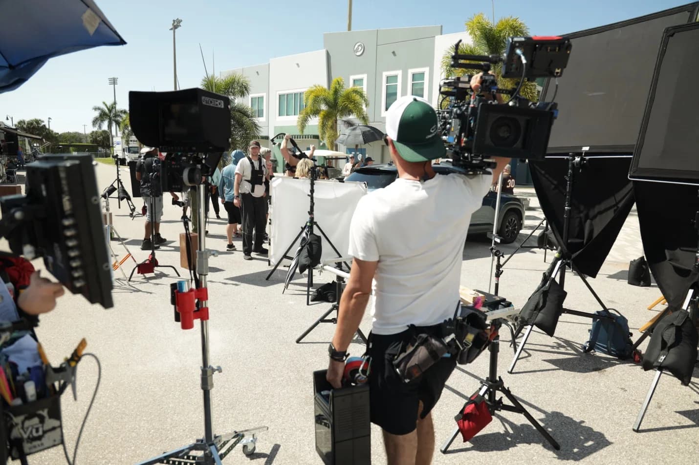 Production crew with cameras, monitors, and lighting stands preparing an exterior scene