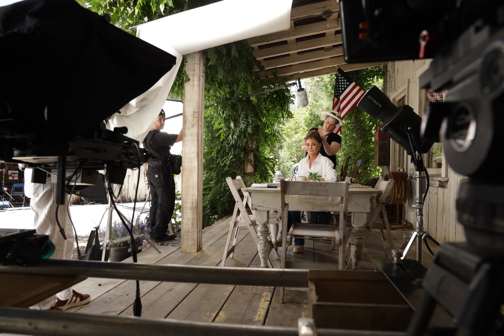 Performers on a porch with a production camera in the foreground