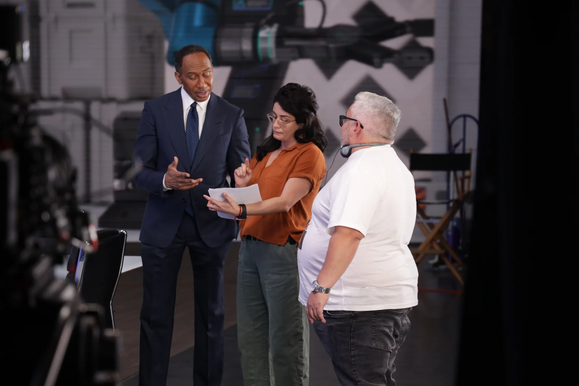 Three people discussing a scene on a production set